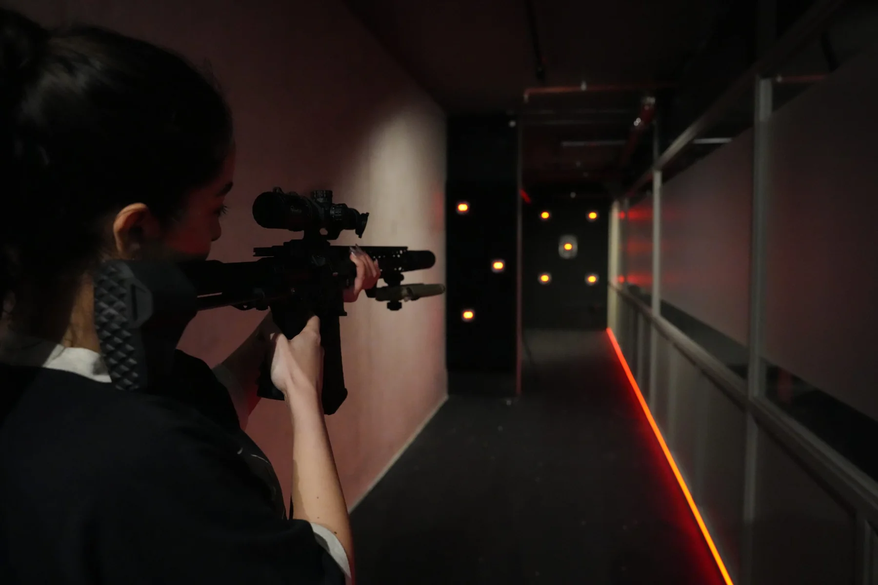 Visitor aiming an airsoft rifle in an Aldgate shooting lane
